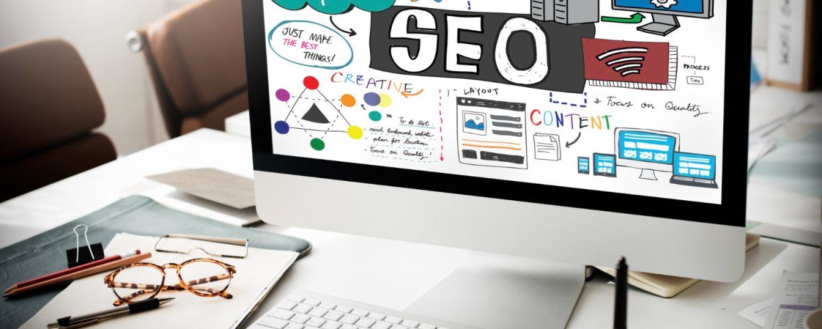 Firmă SEO ilustrată printr-un laptop pe birou și elemente vizuale de optimizare